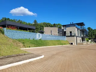 Fachada de uma residência em Lajeado, Brasil, com jardim e área pavimentada.