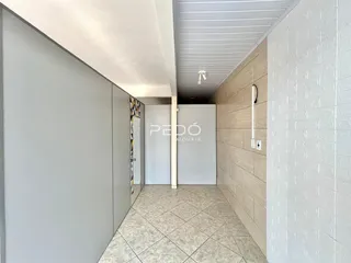 Hall de entrada com piso de cerâmica e paredes claras.