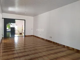 Espaço interno com piso de cerâmica e porta de acesso a outra área.