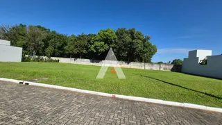 Vista externa de um terreno com gramado verde e cerca branca.