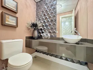 Foto de um banheiro com louças sanitárias e revestimentos de parede.