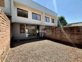Fachada de uma residência em Lajeado, Brasil, com muro de tijolos à esquerda.