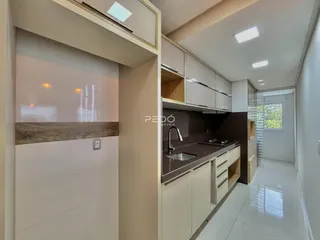 Foto de uma cozinha moderna com armários brancos e bancadas escuras.
