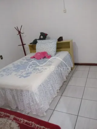 Quarto com cama coberta com lençóis brancos e azuis.