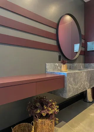 Vista de uma bancada de cozinha moderna com armários em tons de rosa e cinza.