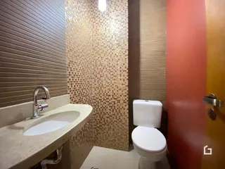 Foto de um banheiro com azulejos e louças sanitárias.