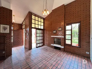 Sala com paredes de tijolo aparente e piso de cerâmica.