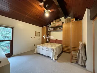 Quarto com cama e armários de madeira no interior da residência.
