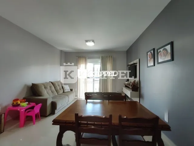 Foto de uma sala de estar com sofá e mesa de madeira em um imóvel.