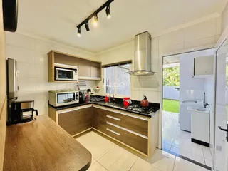 Foto de uma cozinha com armários de madeira e bancadas escuras.