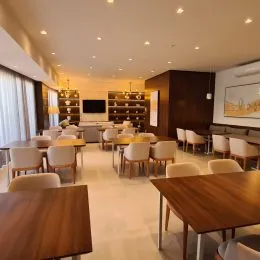 Sala de estar com piso claro e iluminação embutida.