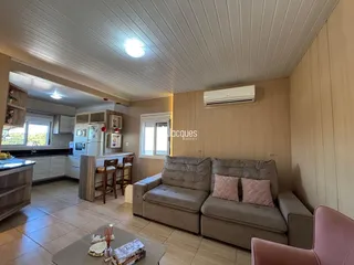 Sala de estar com sofá e piso de cerâmica em um imóvel em Lajeado.