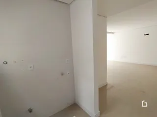 Interior de um espaço com paredes brancas e piso claro.