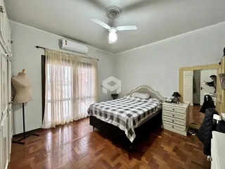 Quarto com piso de madeira e janela iluminada.