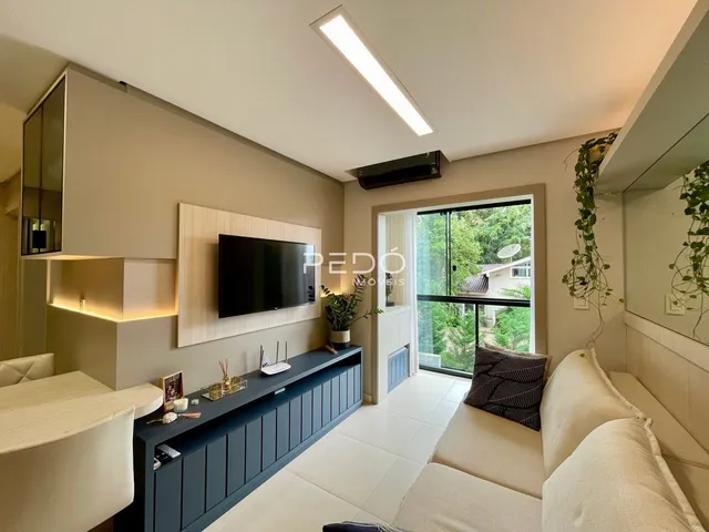 Sala de estar moderna com sofá e televisão em um apartamento no Brasil.