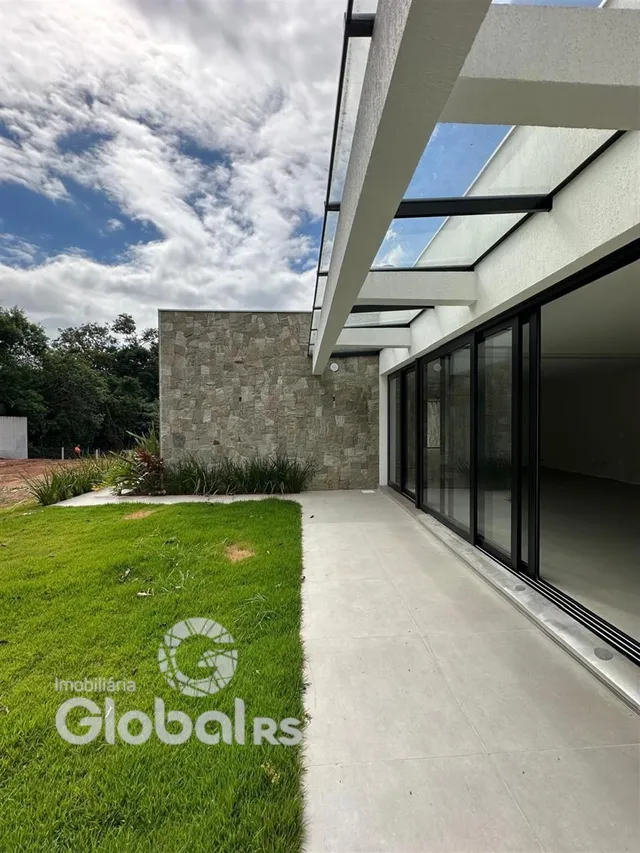 Vista da fachada de uma residência com jardim e pátio.