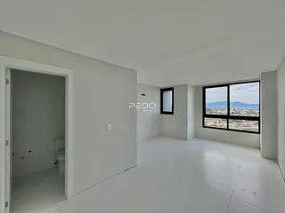 Ambiente interno de uma sala com vista para a paisagem.