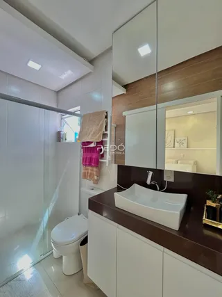 Foto de um banheiro moderno com box de vidro e bancada escura.