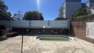 Vista externa de uma propriedade com parede de tijolos e uma área externa.