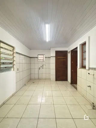 Corredor interno com piso de cerâmica e paredes brancas.