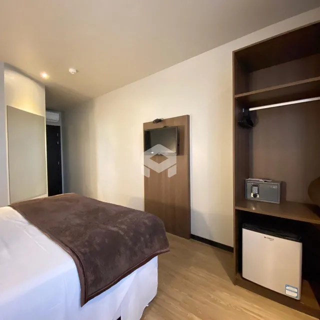 Quarto com cama e armário de madeira em um apartamento.