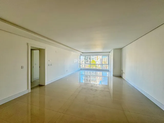 Corredor interno de uma residência com piso claro e grande janela.