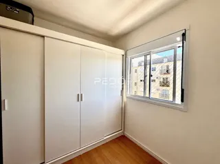 Vista interna de um cômodo com armários embutidos e uma janela.