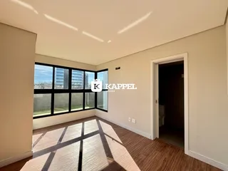 Uma sala de estar com grandes janelas que oferecem uma vista urbana.