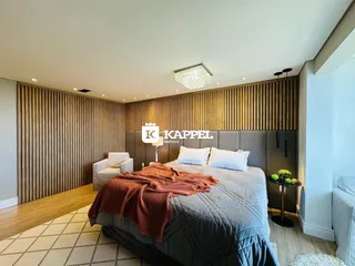 Quarto com cabeceira de painel de madeira e cama grande.