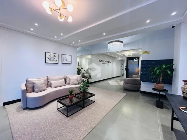 Sala de estar moderna com sofá e decoração em um apartamento.