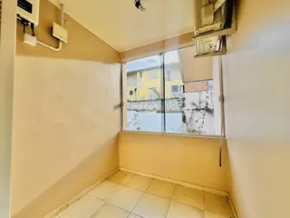 Interior de um cômodo com piso de cerâmica e janela.