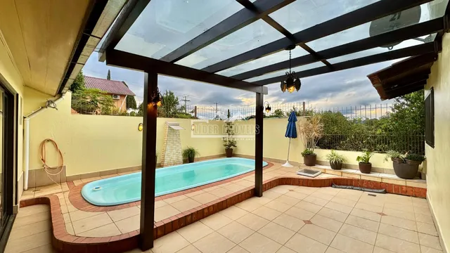 Foto de uma piscina externa em um pátio com estrutura de madeira.