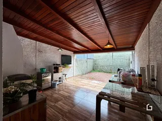 Ambiente interno com piso de cerâmica e teto de madeira em uma residência.