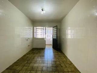 Corredor interno com piso de cerâmica e paredes brancas.