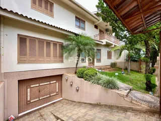 Fachada de uma residência em Lajeado, Brasil, mostrando a área da garagem e o jardim.