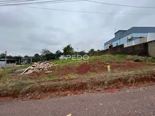 Vista externa de uma propriedade com terra e vegetação ao lado de uma estrada.