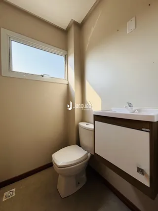 Foto de um banheiro interno com janela e vaso sanitário.
