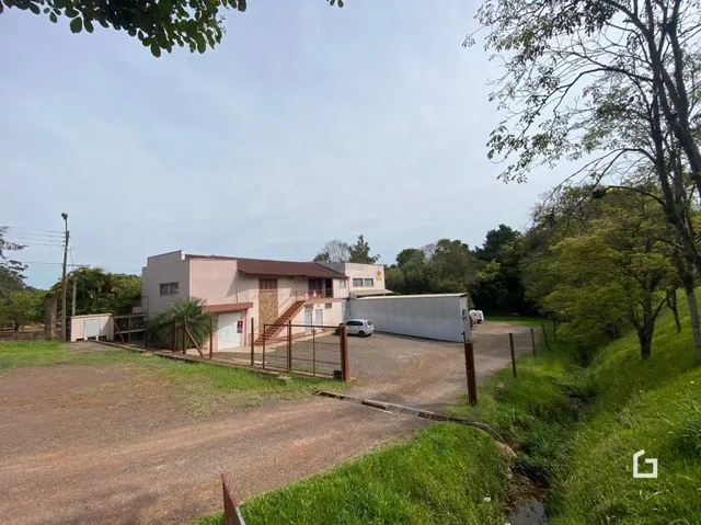 Fachada de uma propriedade rural em Lajeado, Brasil, com vegetação ao redor.