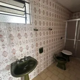 Parede interna com papel de parede estampado e pia visível em um ambiente.