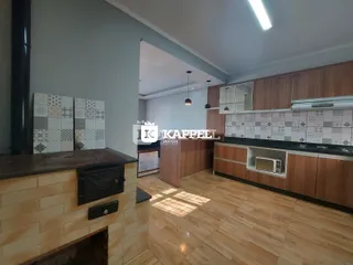 Esta é uma foto de uma cozinha com armários de madeira e piso de madeira clara.