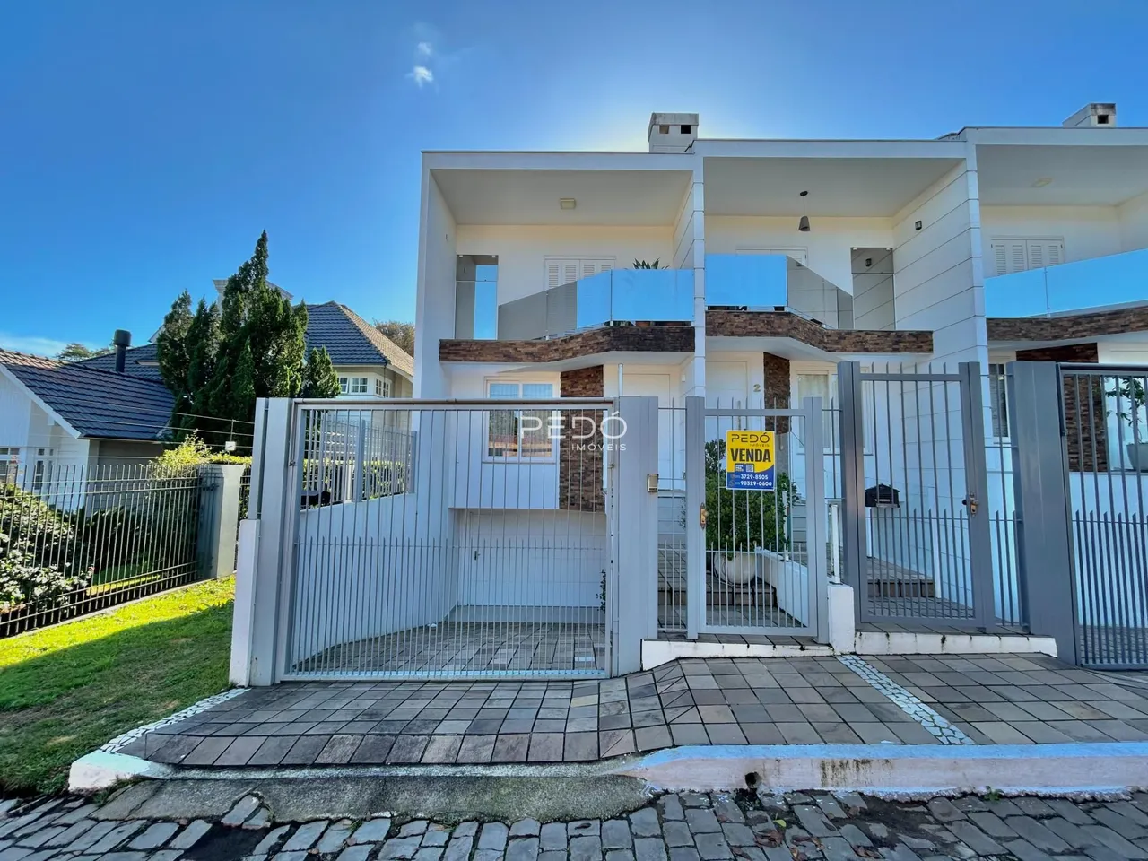 Fachada de uma residência moderna com portão de metal em Lajeado, Brasil.