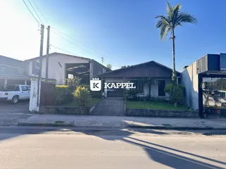 Fachada de uma residência em Lajeado, Brasil, com vegetação ao redor.