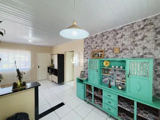 Interior de uma sala com móveis de madeira e piso cerâmico.