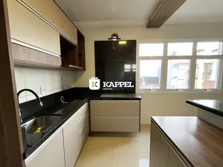 Foto de uma cozinha com armários superiores e inferiores e bancada escura.