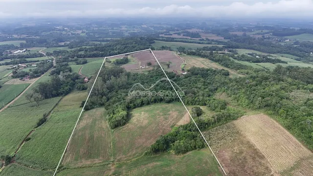 Vista aérea de uma propriedade rural com campos e vegetação.
