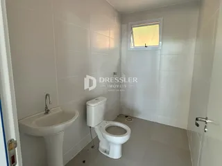 Interior de um banheiro com revestimento cerâmico branco.