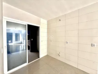 Interior de um cômodo com porta de vidro abrindo para uma área externa.
