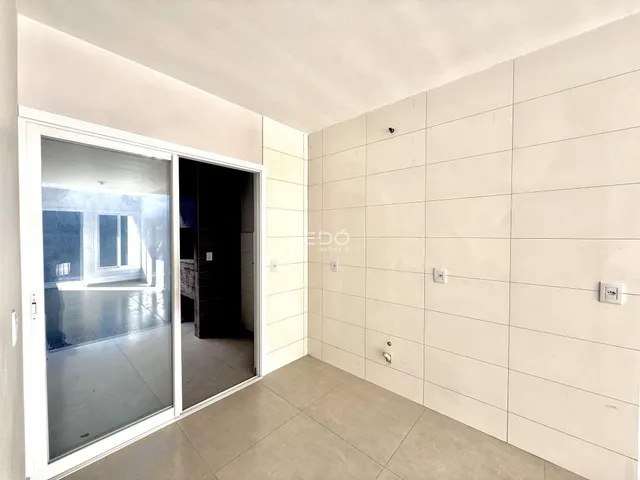 Interior de um cômodo com porta de vidro abrindo para uma área externa.