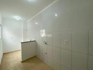 Vista de um corredor interno com paredes brancas e piso de cerâmica.
