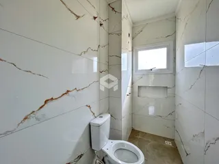 Foto de um banheiro com revestimento de mármore branco.